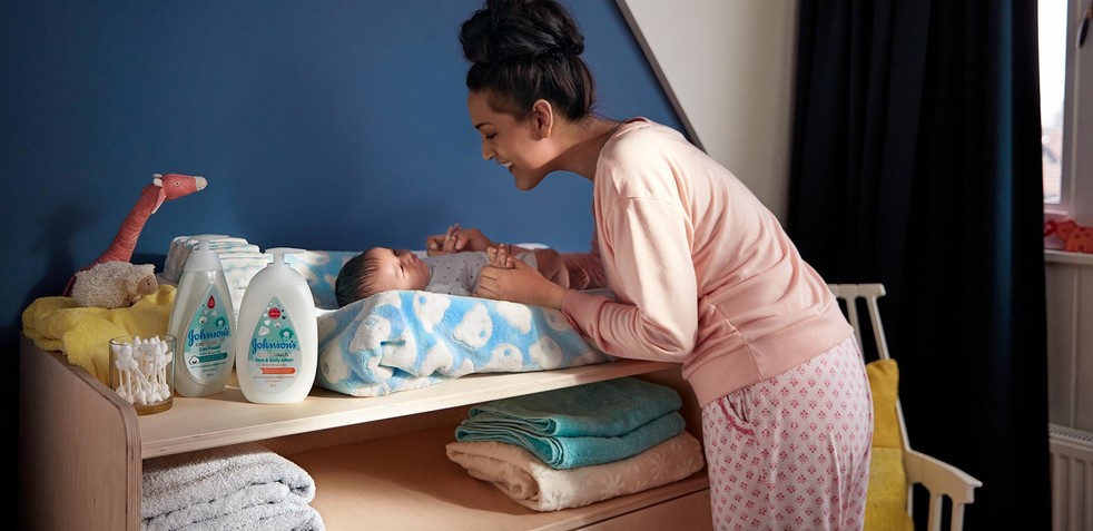 Mother and baby in nursery with Johnson’s® baby products