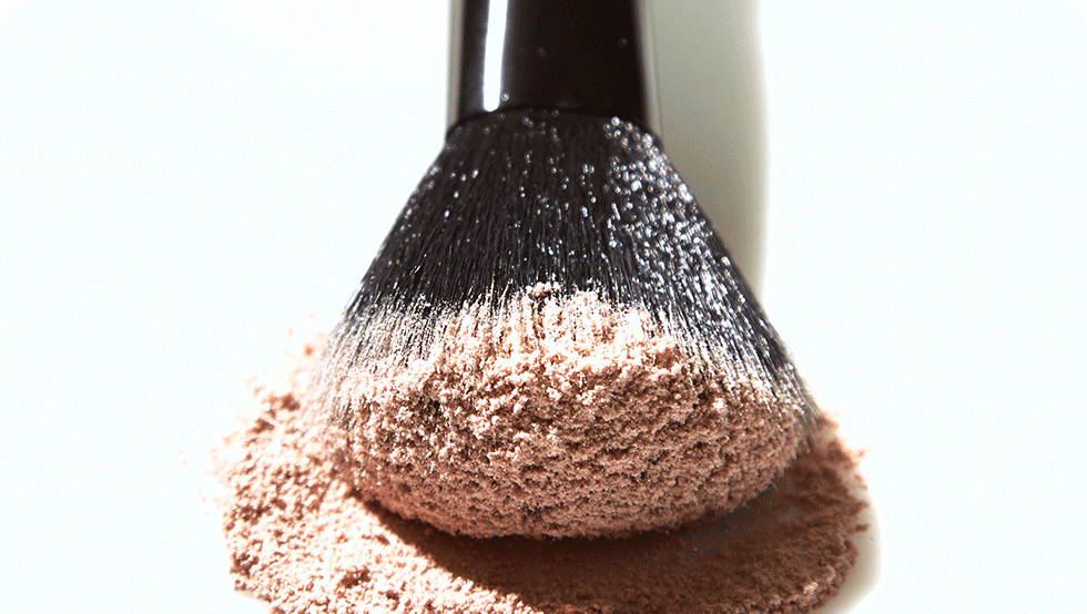 A makeup brush covered in powder