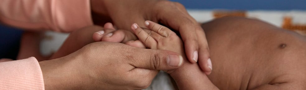 Mother massaging baby's hand