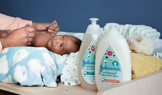 Baby next to Johnson’s® newborn skin care products